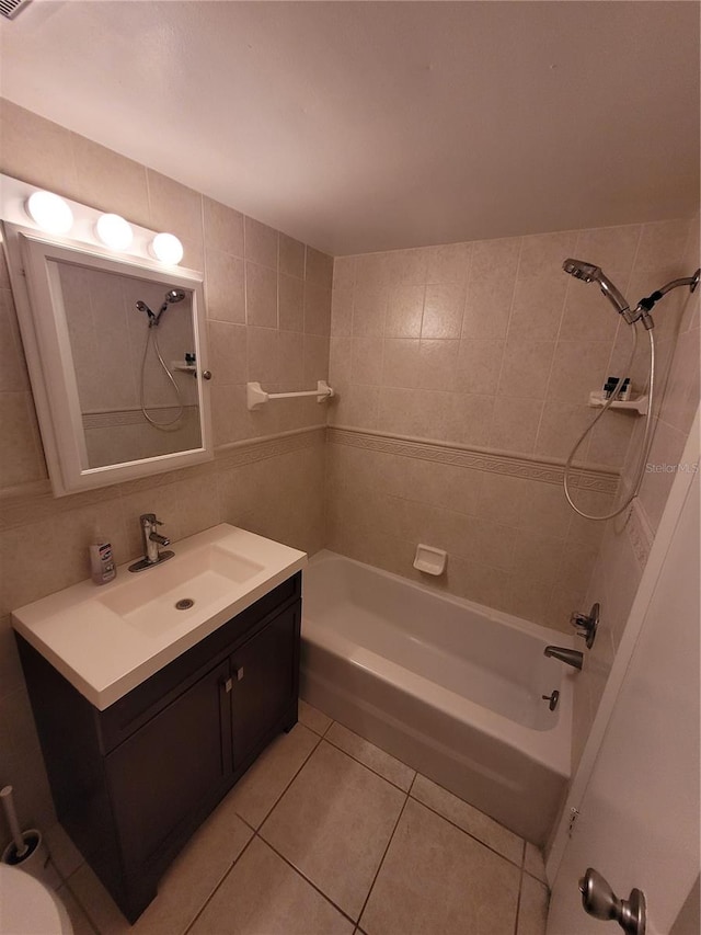 bathroom featuring tiled shower / bath, vanity, tile patterned floors, and tile walls