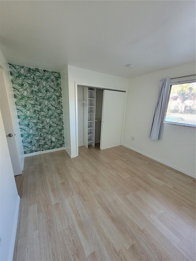 unfurnished bedroom with light hardwood / wood-style floors and a closet