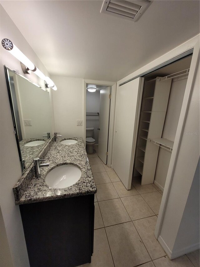 bathroom with tile patterned flooring, vanity, and toilet