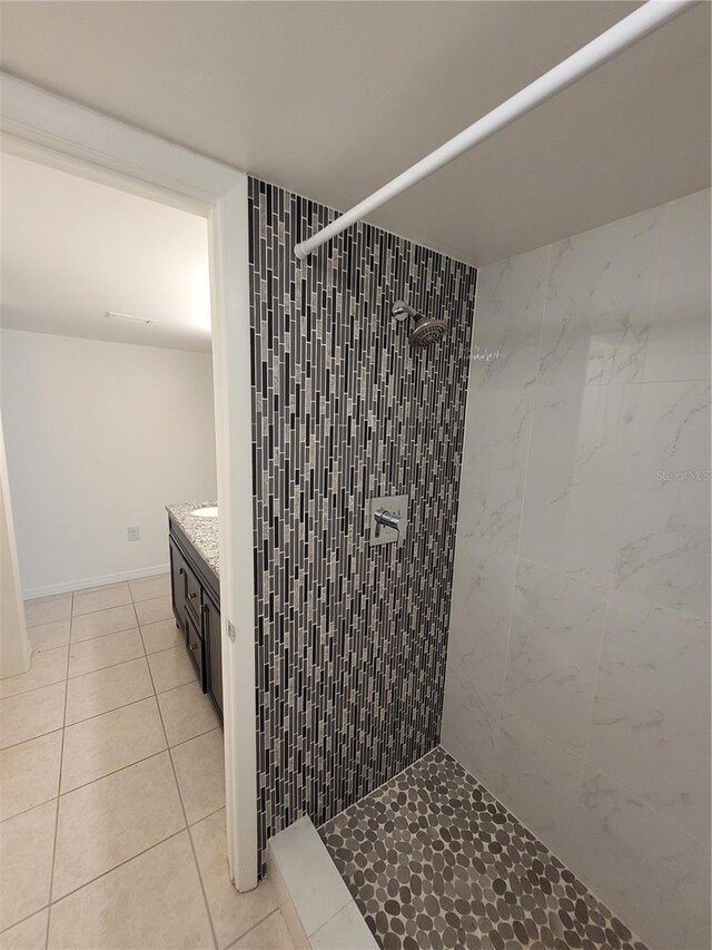 bathroom featuring tile patterned floors, vanity, and a tile shower