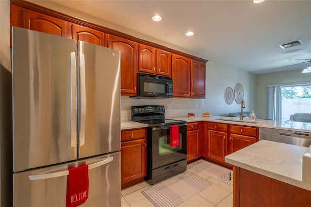 kitchen featuring sink, backsplash, kitchen peninsula, light tile patterned floors, and black appliances