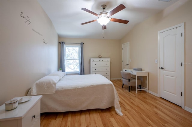 bedroom featuring ceiling fan, light wood-type flooring, and vaulted ceiling