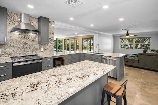 kitchen featuring stainless steel appliances, visible vents, gray cabinetry, open floor plan, and wall chimney range hood