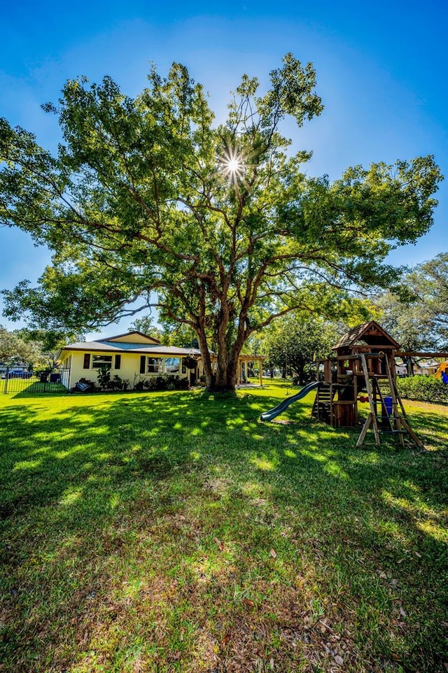 view of yard with a playground and fence