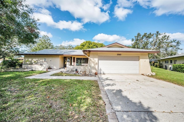 ranch-style house featuring a front lawn and a garage