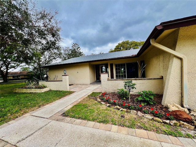 view of front facade with a front lawn and stucco siding