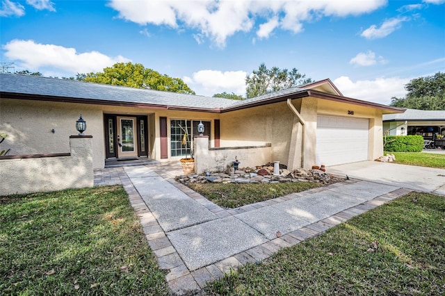 ranch-style house with driveway, a front lawn, an attached garage, and stucco siding