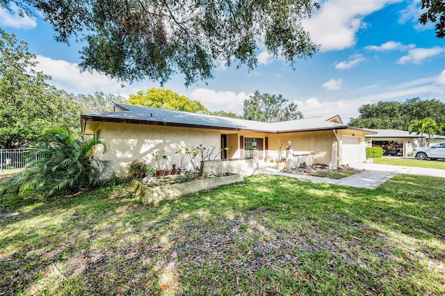 ranch-style home with a front lawn, an attached garage, fence, and stucco siding