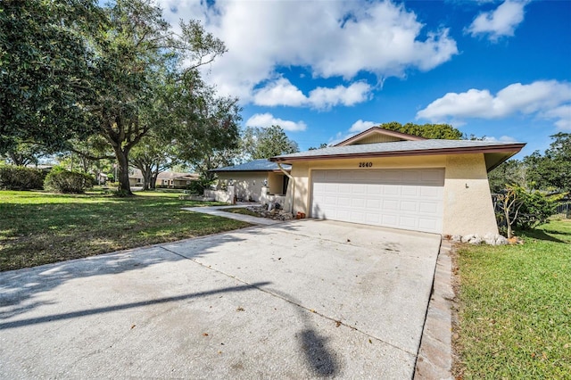 view of front of house featuring concrete driveway, an attached garage, a front lawn, and stucco siding