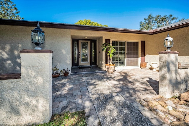 view of exterior entry featuring stucco siding