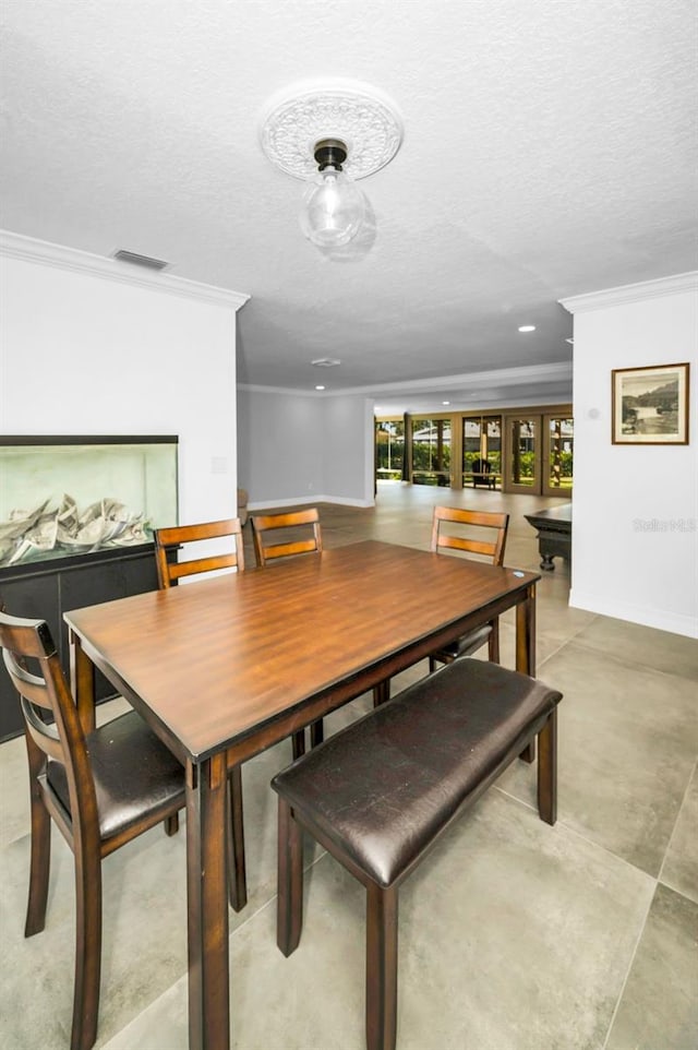 dining area featuring visible vents, crown molding, and a textured ceiling