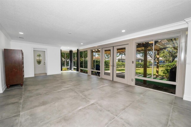 unfurnished living room with visible vents, french doors, a textured ceiling, crown molding, and recessed lighting