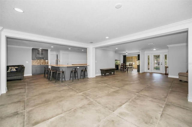 interior space featuring crown molding, a sink, and baseboards