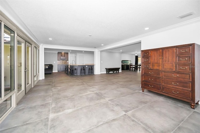 unfurnished living room with ornamental molding, recessed lighting, visible vents, and baseboards