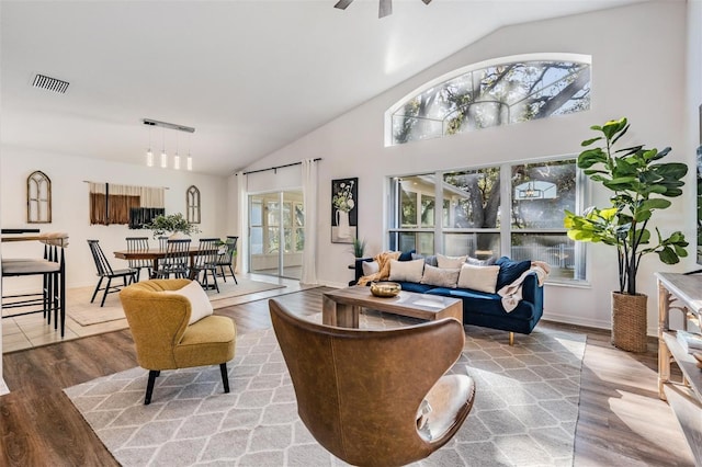 living room featuring ceiling fan, wood-type flooring, and high vaulted ceiling