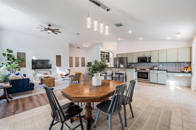 dining area featuring ceiling fan, visible vents, light tile patterned floors, lofted ceiling, and recessed lighting