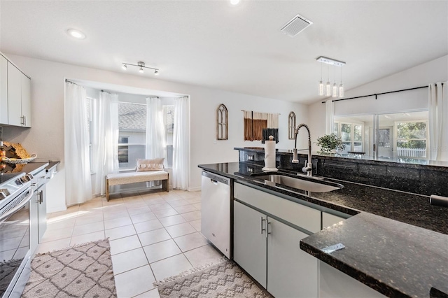 kitchen featuring stainless steel dishwasher, visible vents, electric range oven, a sink, and dark stone countertops