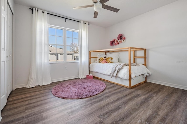 bedroom featuring baseboards, ceiling fan, and wood finished floors
