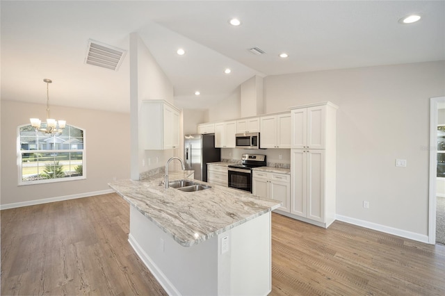 kitchen featuring white cabinets, stainless steel appliances, hanging light fixtures, and sink