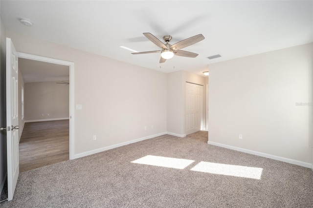 carpeted spare room featuring ceiling fan