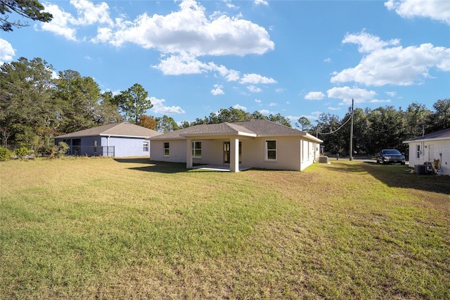 rear view of property featuring cooling unit, a yard, and a patio