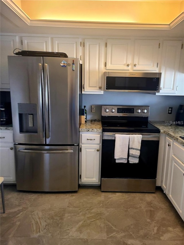 kitchen featuring light stone countertops, white cabinets, and stainless steel appliances