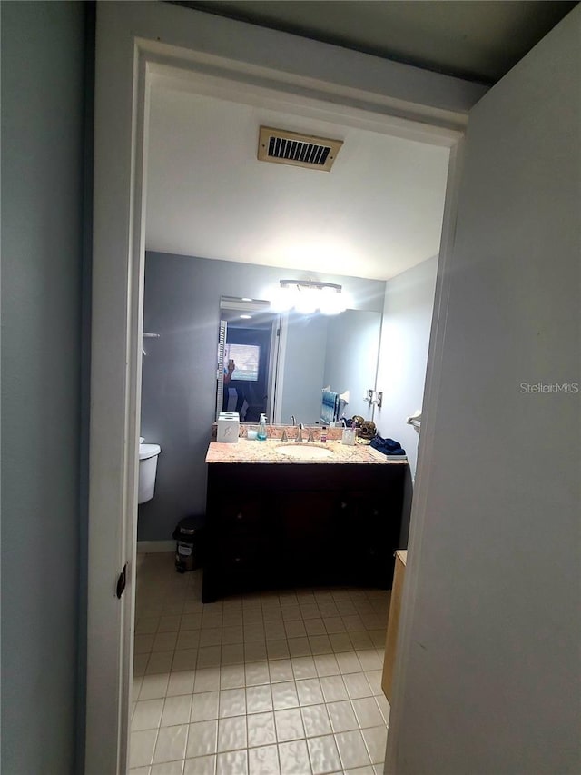 bathroom featuring tile patterned flooring, vanity, and toilet