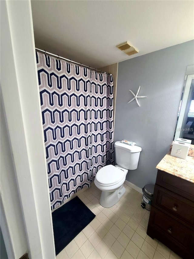 bathroom with tile patterned flooring, vanity, and toilet