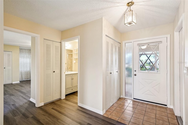 foyer entrance featuring a textured ceiling and light wood-type flooring