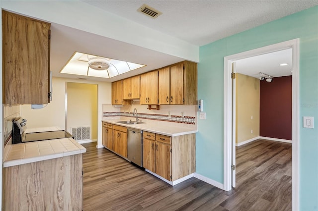 kitchen featuring sink, stainless steel dishwasher, wood-type flooring, a textured ceiling, and range