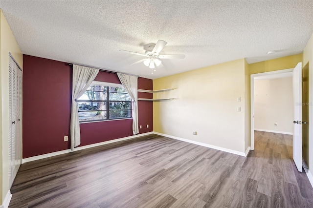 unfurnished bedroom with hardwood / wood-style floors, ceiling fan, a textured ceiling, and a closet