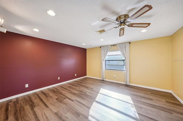 unfurnished room with ceiling fan, light hardwood / wood-style floors, and a textured ceiling