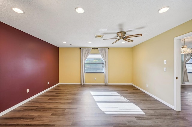 unfurnished room featuring ceiling fan, hardwood / wood-style floors, and a textured ceiling