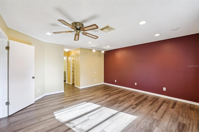 spare room featuring a textured ceiling, light hardwood / wood-style floors, and ceiling fan