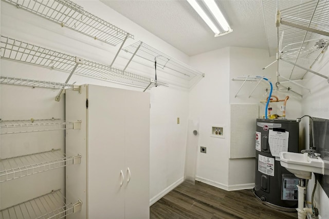 laundry room featuring hookup for an electric dryer, hookup for a washing machine, dark hardwood / wood-style floors, and water heater