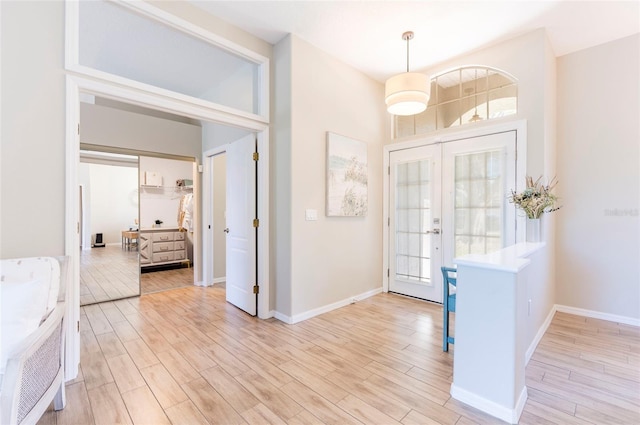 foyer with french doors and light hardwood / wood-style flooring