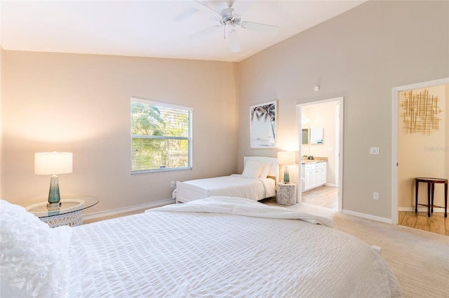 bedroom featuring ensuite bathroom, ceiling fan, lofted ceiling, and light wood-type flooring