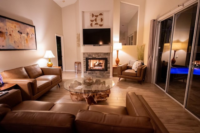 living room featuring hardwood / wood-style floors, a fireplace, and high vaulted ceiling