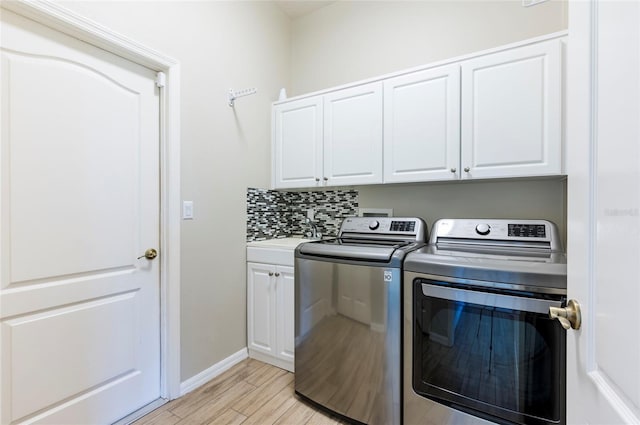 laundry room with separate washer and dryer, light hardwood / wood-style flooring, cabinets, and sink