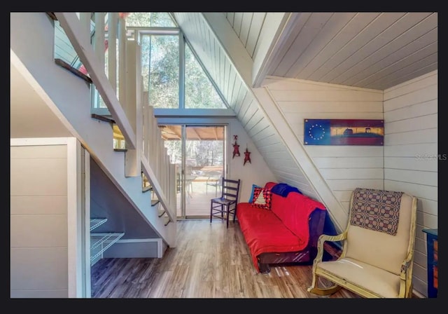 living area with wood walls, wooden ceiling, vaulted ceiling, and hardwood / wood-style flooring