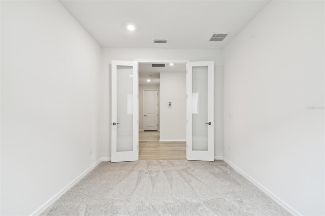 unfurnished bedroom featuring light colored carpet and french doors