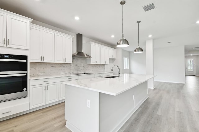 kitchen featuring white cabinets, wall chimney exhaust hood, and sink