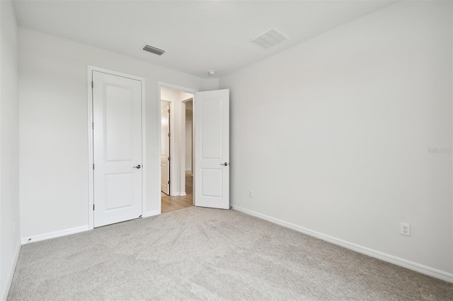 unfurnished bedroom with light colored carpet