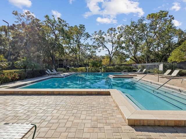 1901 Lennox Rd E Unit 1901, Palm Harbor, FL 34683 - community pool featuring a jacuzzi, a patio area, and view of wooded area