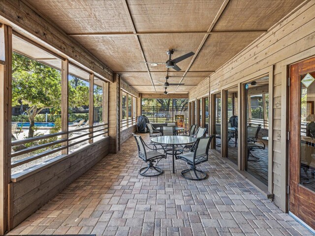 unfurnished sunroom featuring ceiling fan