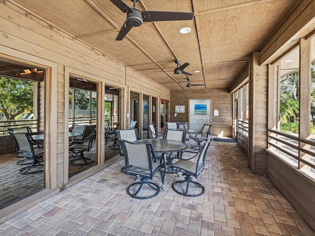 sunroom featuring ceiling fan and wood ceiling