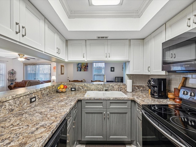 kitchen with black appliances, a raised ceiling, gray cabinetry, and sink