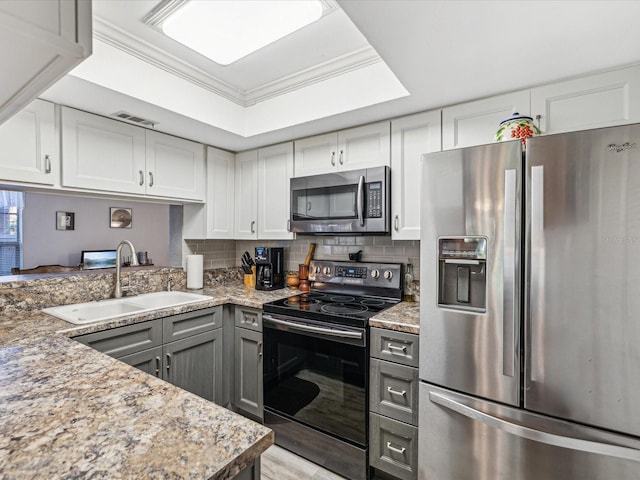 kitchen featuring light stone countertops, appliances with stainless steel finishes, crown molding, and sink