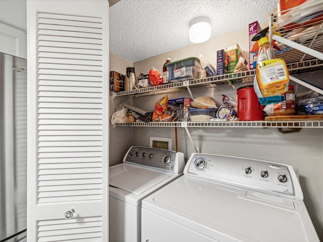 laundry area featuring baseboard heating, a textured ceiling, and independent washer and dryer