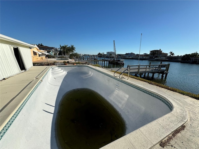 view of swimming pool with a boat dock and a water view